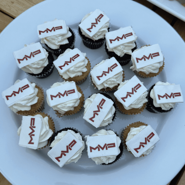 a plate of mini cupcakes with a white and red mvp logo on top